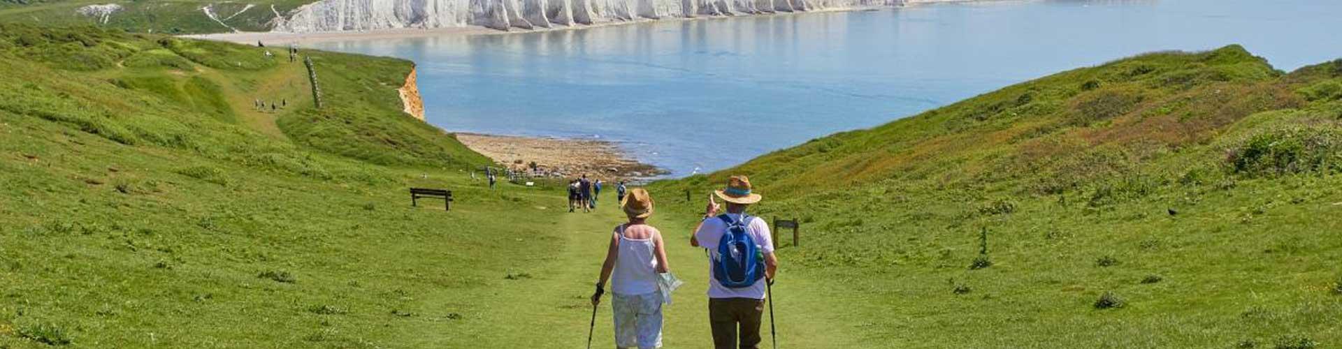 An Image of an Elderly Couple Walking Towards the Sea down a Cliff Top Walk