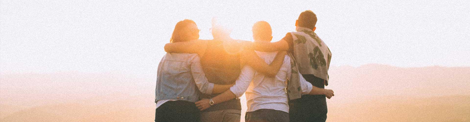 A Group of People in an Embrace with their backs to the Camera